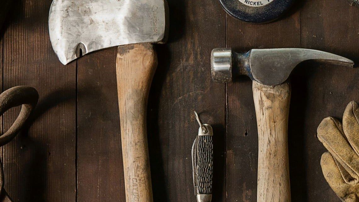 Tools for manual labor displayed on a wood surface